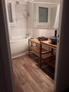 a bathroom with a tub and a table and a sink at Chambre Salon Sdb Jardin près Bordeaux in Cestas