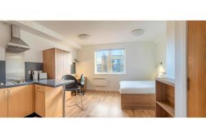 a room with a kitchen and a bedroom with a bed at UHI Dornoch- Campus Accommodation in Dornoch