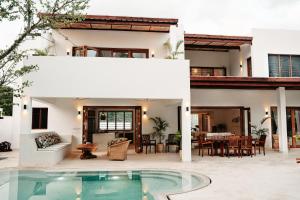a house with a swimming pool and a patio at Eden Escapes - Diani Beach, Kenya in Diani Beach