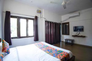 パナジにあるFabHotel Comfort Stays - Nr Miramar Beachのベッドとテレビのある寝室