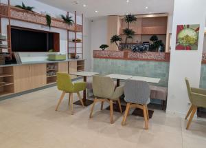 a dining room with a table and chairs and a kitchen at Hôtel Carré Vieux Port in Marseille