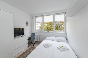 Un dormitorio blanco con una cama y un escritorio. en Pramonės Apartment #7 by PoloApartments, en Kaunas