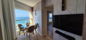 バト・ヤムにあるUrban Beach Apartmentsのテーブルと大きな窓のあるリビングルーム