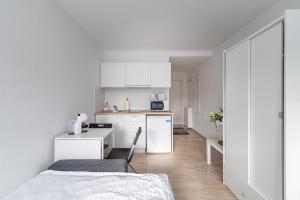 a small white kitchen with a table and a chair at Pramonės Apartment #8 by PoloApartments in Kaunas