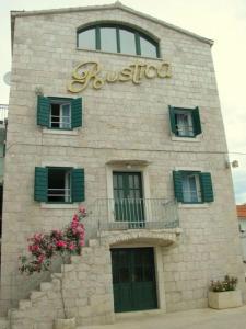 um edifício de pedra com um sinal em Villa Rustica Dalmatia em Seget Vranjica