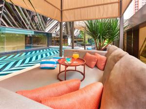 新加坡Pullman Singapore Orchard的一个带沙发和桌子的游泳池