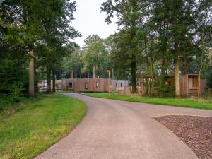 a winding road with a building in the distance at Cosy Forest Hideaway for Two in Antoing