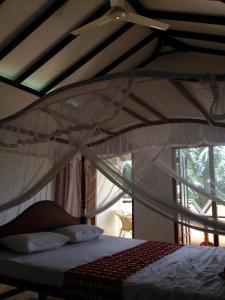 a bedroom with a bed with a mosquito net at Kabalana Design House Villa in Ahangama