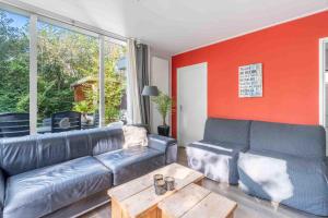 a living room with a leather couch and a table at Pelikaanweg 21 in De Koog
