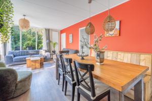 a dining room and living room with a wooden table and chairs at Pelikaanweg 21 in De Koog
