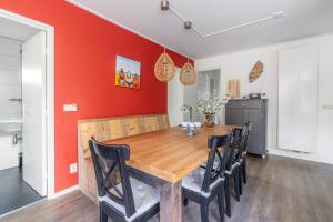 a dining room with a wooden table and black chairs at Pelikaanweg 21 in De Koog