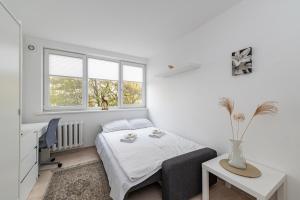 a bedroom with a bed and a desk and window at Pramonės Apartment #9 by PoloApartments in Kaunas