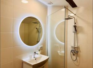 a bathroom with a sink and a shower with a mirror at Yu-home in Mukacheve