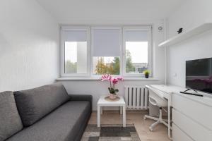 a living room with a couch and a desk at Pramonės Apartment #10 by PoloApartments in Kaunas