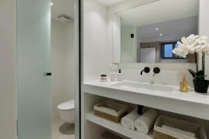 un bagno con lavandino, water e specchio di Vivant Naousa Residence 1 a Naoussa
