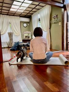 a woman sitting on the floor with a cat at Milk-ya Women-Only Guest House in Yomitan