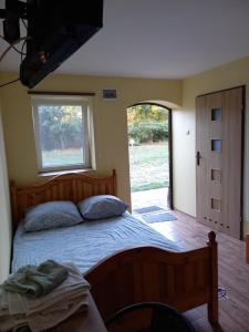 a bedroom with a large bed and a window at Chata Kurpiowska in Nowogród