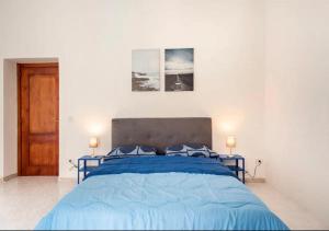 a bedroom with a blue bed with two blue pillows at Spagno li's House in Naples