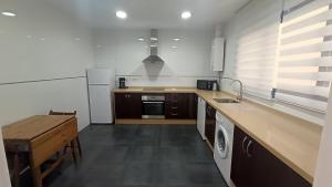 kuchnia ze zlewem i stołem w obiekcie Livingtarifa Apartamento La Marea w mieście Tarifa