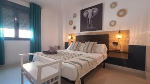 sypialnia z dużym białym łóżkiem i stołem w obiekcie Livingtarifa Apartamento La Marea w mieście Tarifa