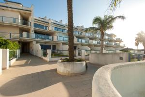 duży budynek z palmą przed nim w obiekcie Livingtarifa Apartamento La Marea w mieście Tarifa