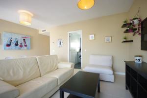 a living room with a white couch and a table at Livingtarifa Apartamento Entre Dos Aguas in Tarifa