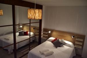 sypialnia z dwoma łóżkami i dużym lustrem w obiekcie Livingtarifa Apartamento Anhelo w mieście Tarifa