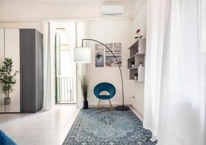 a living room with a blue chair and a lamp at Spagno li's House in Naples