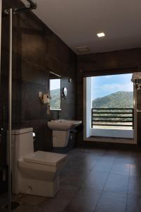 a bathroom with a toilet and a sink and a window at فندق إكليل الجبل in Al Shafa +30 photos
