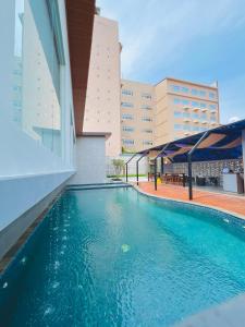 a swimming pool on the side of a building at Azana Asia Hotel Cilacap in Sidanegara