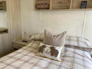 a bedroom with a bed with two pillows on it at Coastal Caravan Holidays - Nightingale 8 in Tunstall +35 photos
