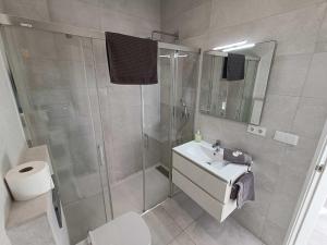 łazienka z prysznicem, toaletą i umywalką w obiekcie Livingtarifa Apartamento La Palmera w mieście Tarifa +8 zdjęć