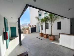 otwarty korytarz budynku z palmami w obiekcie Livingtarifa Apartamento La Palmera w mieście Tarifa