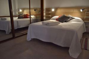 pokój hotelowy z dwoma łóżkami i lustrem w obiekcie Livingtarifa Apartamento Anhelo w mieście Tarifa