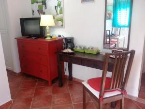 a desk with a television and a red dresser at Apartment Smeraldo in Bayahibe
