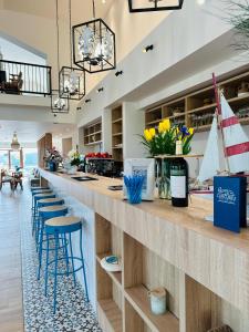 a lobby with a bar with blue stools at Resort Plaza Lake in Rojiştea