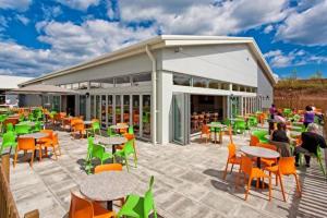 a patio with tables and chairs and a building at Coastal Caravan Holidays - Nightingale 8 in Tunstall