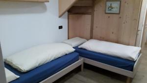 una camera con due letti in una piccola stanza di Appartamenti Dany ad Arabba