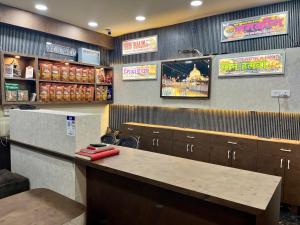 a restaurant with a counter and signs on the wall at Hotel Kaka Inn in Ajmer