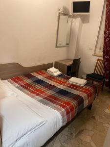 a hotel room with a bed and a chair at HOTEL BISSI in Milan