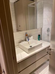 ein Badezimmer mit einem weißen Waschbecken und einem Spiegel in der Unterkunft Low Price Luxury Apartment Perfect for An Amazing stay In ISTANBUL in Istanbul