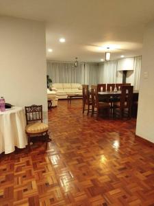 a living room with a wooden floor and a table and chairs at Amplio excelente ubicación Calacoto in Irpavi