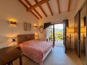a bedroom with a bed and a sliding glass door at Villa KALLISTE 3 pièces avec vue mer sur les hauteurs de Propriano in Propriano