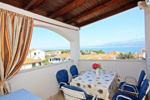 a table on a balcony with a view of the water at Apartments Lucia in Supetar