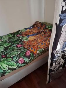 a bed with a colorful blanket on top of it at Tunnelmallinen retroyksiö in Rovaniemi