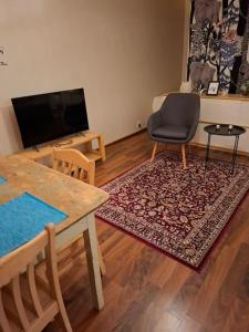 a living room with a table and a television at Tunnelmallinen retroyksiö in Rovaniemi