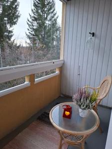 a table and chair on a porch with a window at Tunnelmallinen retroyksiö in Rovaniemi