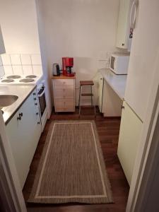 a small kitchen with a sink and a stove at Tunnelmallinen retroyksiö in Rovaniemi +10 photos