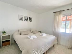 a white bed in a room with a window at Casa Orone in Valle Gran Rey