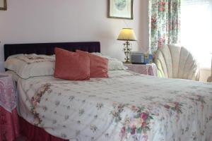 a bedroom with a bed with a floral comforter at Knightsrest in Burnham on Sea